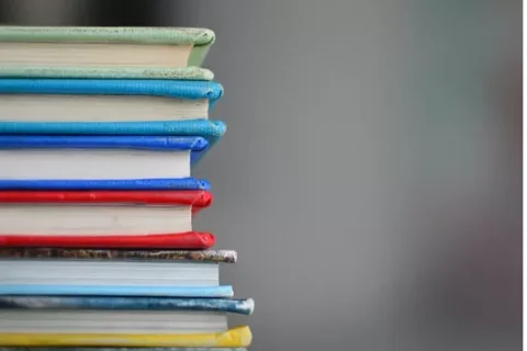 Stack of colorful text books for UCLA Core Competencies