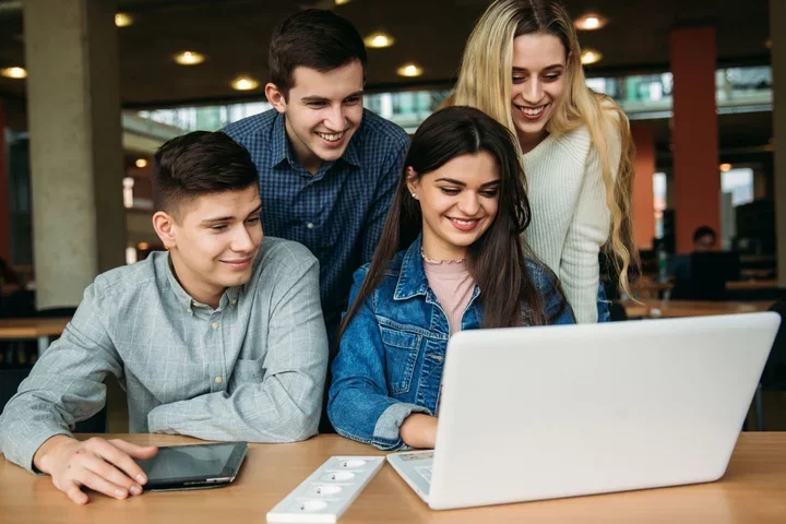 Trainees gathered around a laptop to watch training videos.