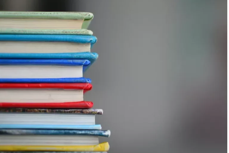 Stack of colorful text books for UCLA Core Competencies