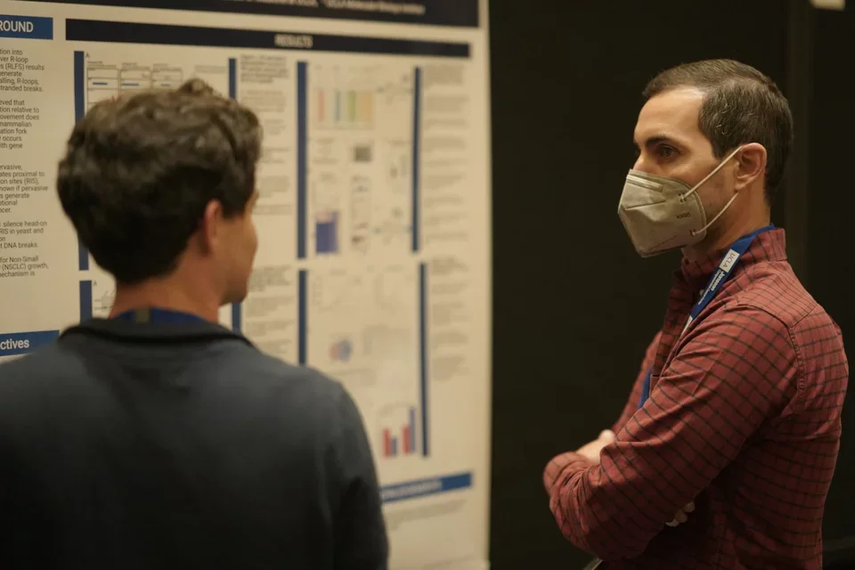 Trainee presenting his poster to a judge at JCCC Retreat poster sessio 