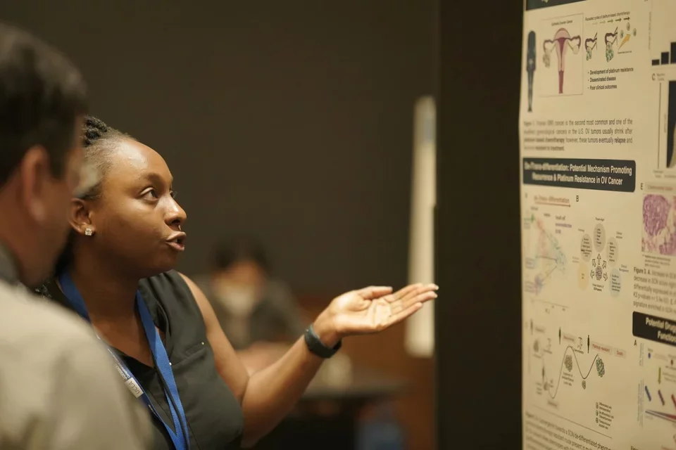 Trainee presenting her poster at the JCCC retreat to judges.