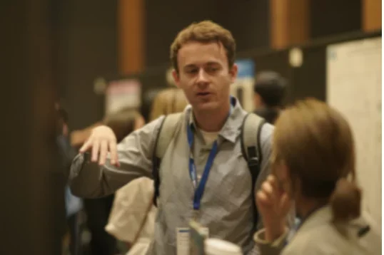 Poster Judge and participant at all member retreat discussion poster board 