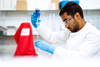 A male trainee conducting a test tube experiment 