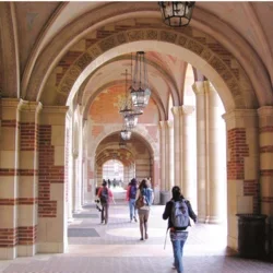 students walking through arches on campus